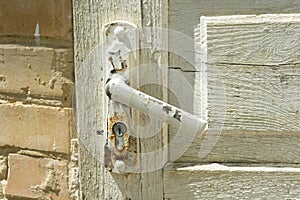 Detail of white vintage wooden door with a painted cracked door handle