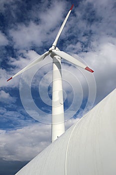 Detail of wind mill power turbine under cloudy sky