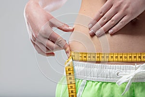Unrecognizable woman, checks fat, unsure of shape