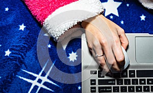 Detail of woman hand using a white mouse over a laptop keyboard. Business concept, close up