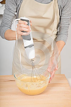 Detail of woman whipping cream with electric mixer