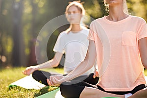 Detail of women doing yoga outdoors at sunrise. Morning meditation
