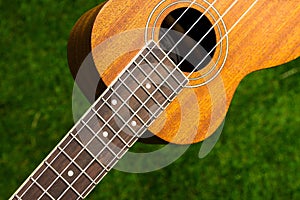 the detail Wooden acoustic guitar ukulele green background