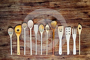 Detail of wooden cooking spoons on textured wooden table, vintage style