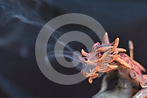 Detail of wooden incense burner in the shape of a dragon breathing smoke