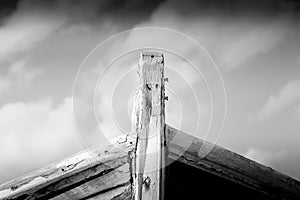 Detail of a wooden shipwreck with cloudy blue sky background.