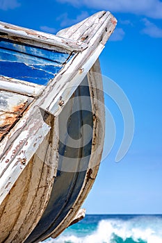 Detail of a wooden shipwreck with turquoise tropical sea background.