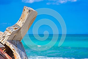 Detail of a wooden shipwreck with turquoise tropical sea background.