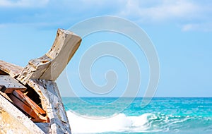 Detail of a wooden shipwreck with turquoise tropical sea background.