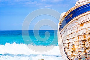 Detail of a wooden shipwreck with turquoise tropical sea background.