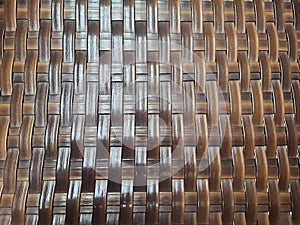 Detail of woven brown wicker armchair, full frame.