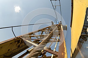 Detail yellow crane jib against a blue sky