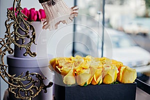 Detail of yellow roses in box with table lamp