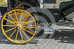 Detail of yellow wheel of horse carriage in Seville Spain