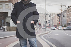 Detail of a young man posing in the city streets