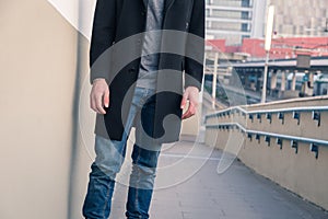 Detail of a young man posing in an urban context