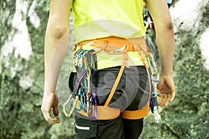 Detail of young man who preparing on a climb and standing a next to rock wall. Equipment for climbing on a man with copy space for