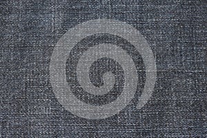 Detailed abstract texture of dark blue denim cloth. Background image of old used denim trousers fabric