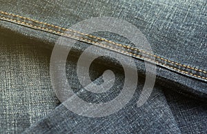 Detailed abstract texture of dark blue denim cloth. Background image of old used denim trousers fabric