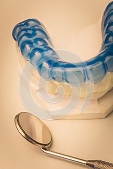 Detailed close up of dental instrument and blue denture or teeth