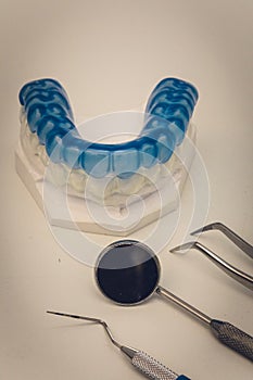 Detailed close up of dental instrument and blue denture or teeth
