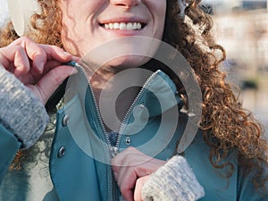 Detailed Close-up of Happy Woman Zipping Up Her Teal Jacket