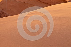 A detailed close-up an orange sand dune in ambient light