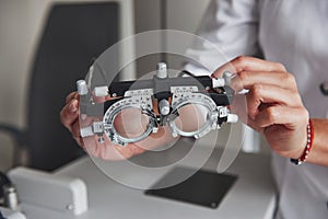 Detailed close up photo. Female hands holding the optical device for eye testing