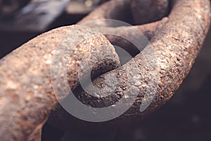 A detailed close up of rusted links in a large chain fence.