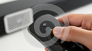 Close Up Thumb Pressing Mute Button On Remote.