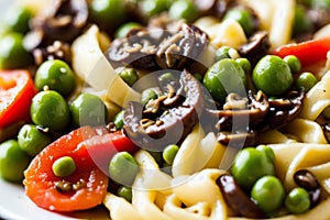 Detailed close-up of vegan Alfredo pasta topped with sauted mushrooms and peas, focusing on the colorful and healthy photo