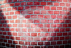 Detailed close up view at a red brick wall with multiple spotlights on it