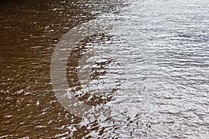 Detailed close up view on reflective water surface with waves and ripples taken at a lake