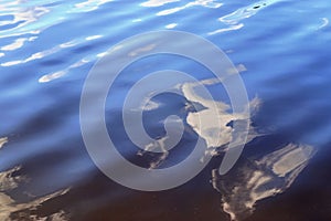 Detailed close up view on water surface with reflection sunlight at the waves and ripples