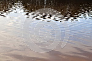 Detailed close up view on water surface with reflection sunlight at the waves and ripples
