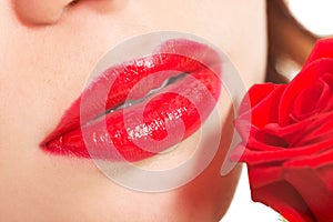 Detailed closeup of woman's red lips with rose.