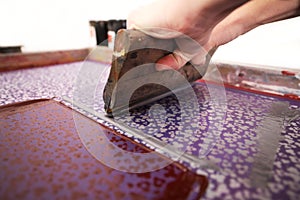 A detailed clover design is printed by hand with a squeegee and silk-screen and grey paint to make exclusive fashion