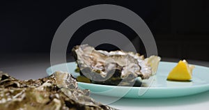 Detailed extreme close-up, open oysters with lemon wedge on a dark background