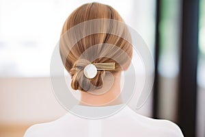 detailed golden hairpin adorning a sleek low chignon