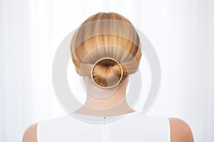 detailed golden hairpin adorning a sleek low chignon