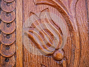 Detailed hand carved flower on traditional hungarian oak wood gate pylon .