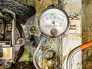 Detailed image of inside of an airplane. Hydraulic lines, valves, tubes, pressure meter