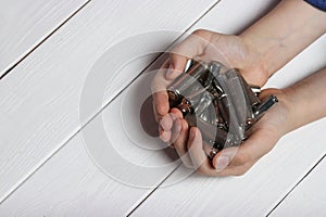 Detailed image of a teenager's hands holding spent finger batteries, promoting waste recycling