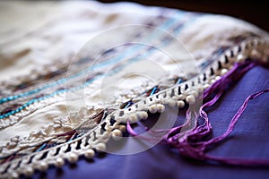 detailed image of tzitzit on the edge of a prayer shawl photo