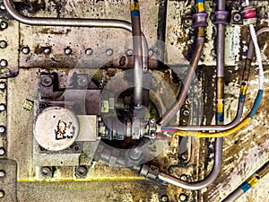 Detailed image of inside of an airplane. Hydraulic lines, valves, tubes, switches and wires