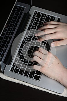 Detailed image of a young person\'s palms poised above a laptop keyboard, symbolizing proficiency in digital communication photo