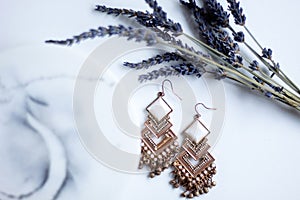 Detailed luxury pair of gold earrings with marble stone