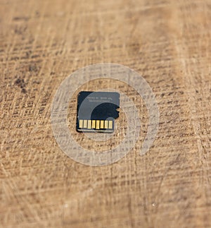 Detailed micro SD card on a wooden table. Micro SD card back side close up shot on a wooden surface. Memory card close up shot on