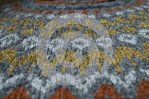 Detailed pattern on hand knitted Icelandic wool jumper. Close up, background.