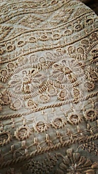 A detailed picture of Indian fabric and showing floral embroideries done by Indian workers.